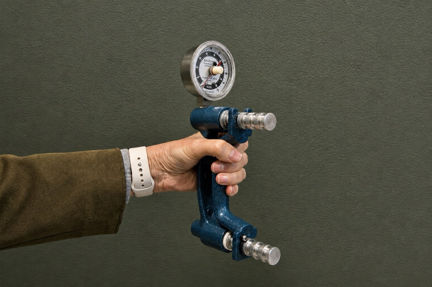 A hand gripping a dynamometer to measure grip strength